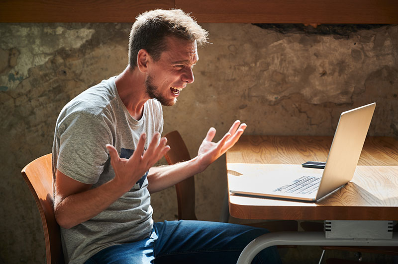 frustrated man yelling at his computer